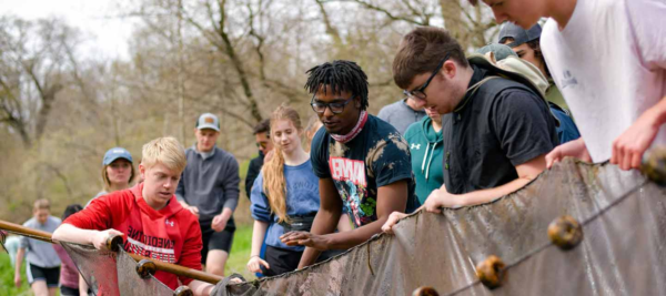 Students work with netting in a stream